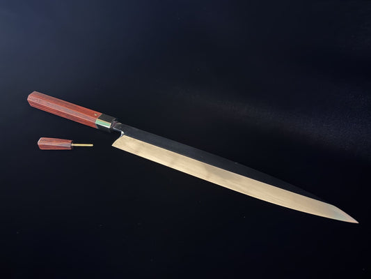 A zenko (all-steel) yanagiba with a red rosewood handle and mekugi peg, hand-forged by Vini Yasu of Yasu Craftworks